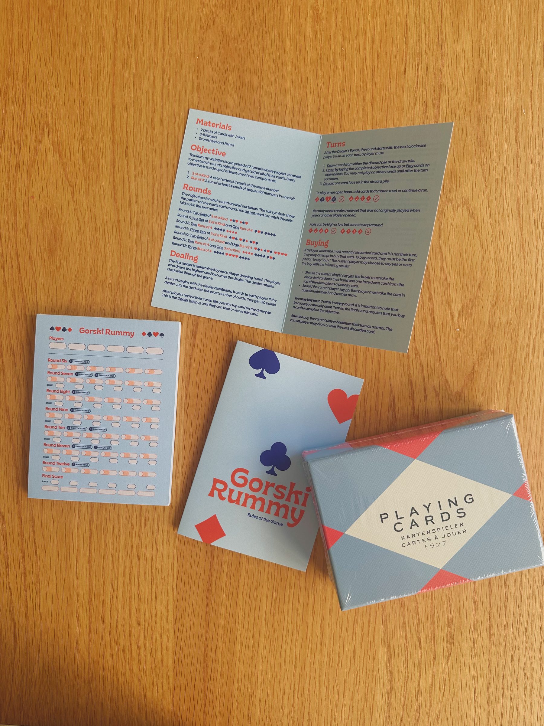 Flatlay of the Gorski Rummy box, rulebook, and score pad